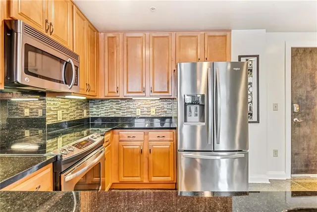 a bathroom with a granite countertop sink toilet and a mirror