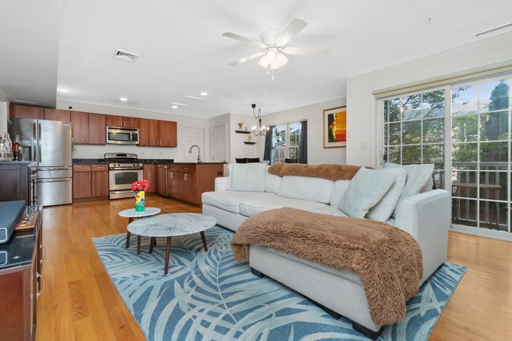 29 Spruce Street, Unit 23 Waltham, MA 02453 - Photo 7 of 26 a living room with furniture and a wooden floor