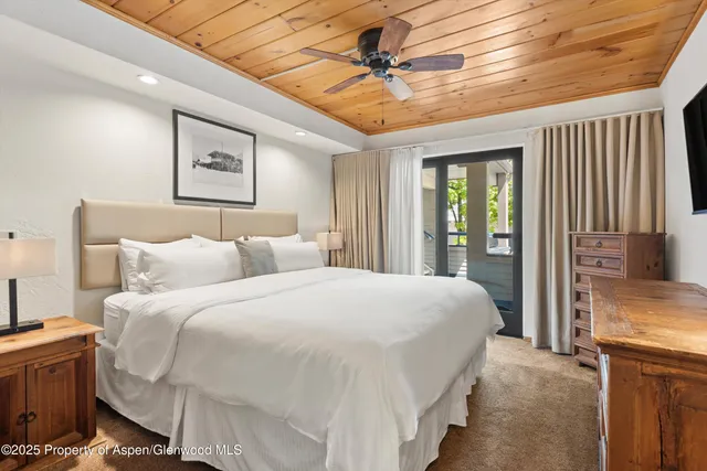 a spacious bedroom with a bed and a chandelier
