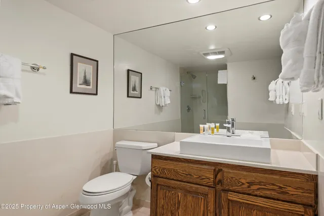a bathroom with a sink mirror vanity and toilet