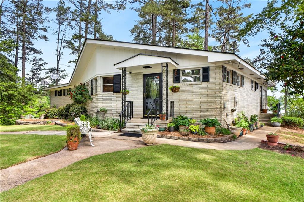 149 Pine Bluff Trail Jackson, GA 30233 - Photo 26 of 59 a front view of a house with a garden and patio
