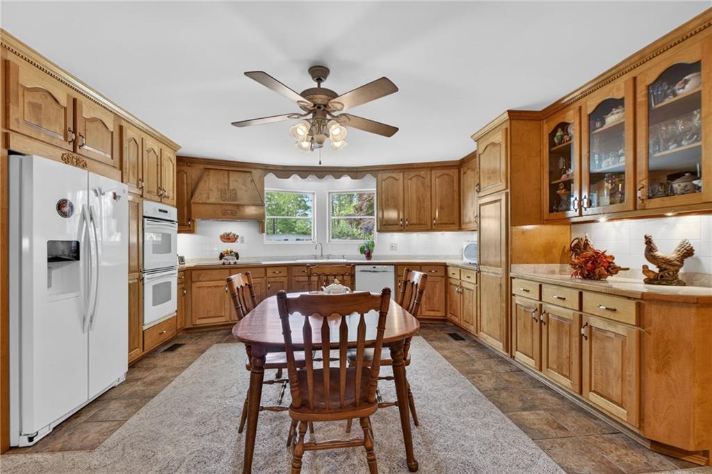 149 Pine Bluff Trail Jackson, GA 30233 - Photo 27 of 59 a kitchen with stainless steel appliances granite countertop a dining table chairs refrigerator and cabinets