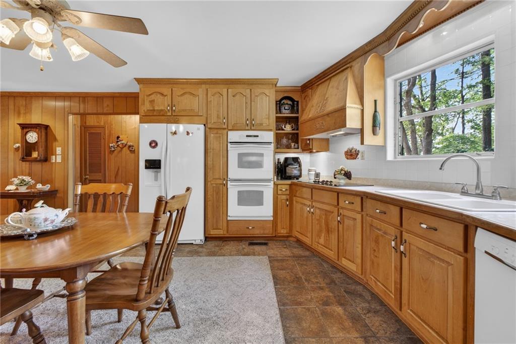 149 Pine Bluff Trail Jackson, GA 30233 - Photo 28 of 59 a kitchen with stainless steel appliances granite countertop a refrigerator a sink dishwasher a dining table and chairs with wooden floor