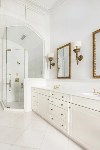 a bathroom with a granite countertop sink two mirror and a bathtub