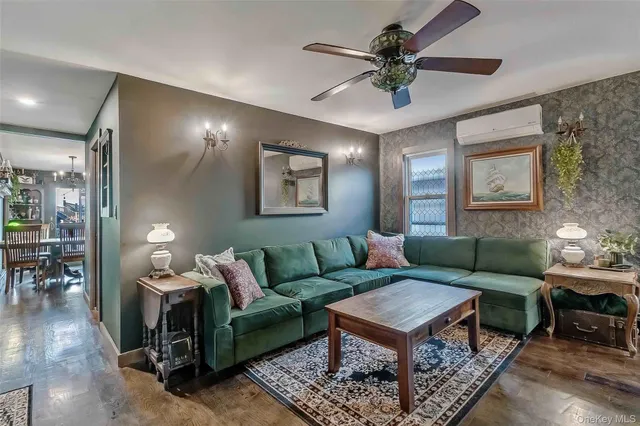 a living room with furniture a chandelier and a potted plant