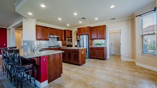 a kitchen with stainless steel appliances granite countertop a stove a sink and a refrigerator