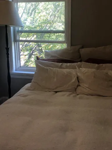 a bed sitting in a bedroom next to a window