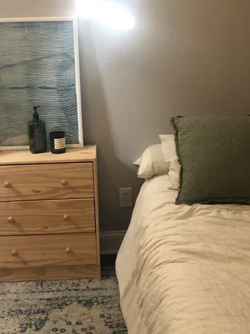 a bed sitting in a bedroom next to a bathroom