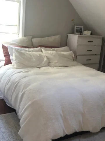 a bedroom with a bed and a window