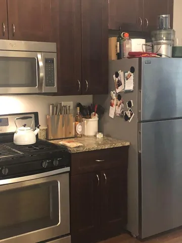 a kitchen with stainless steel appliances granite countertop a stove a refrigerator and a microwave