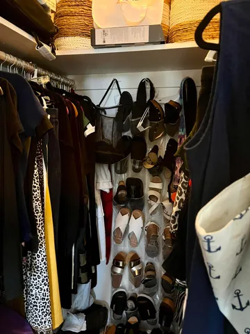 a view of walk in closet with clothes and shoes