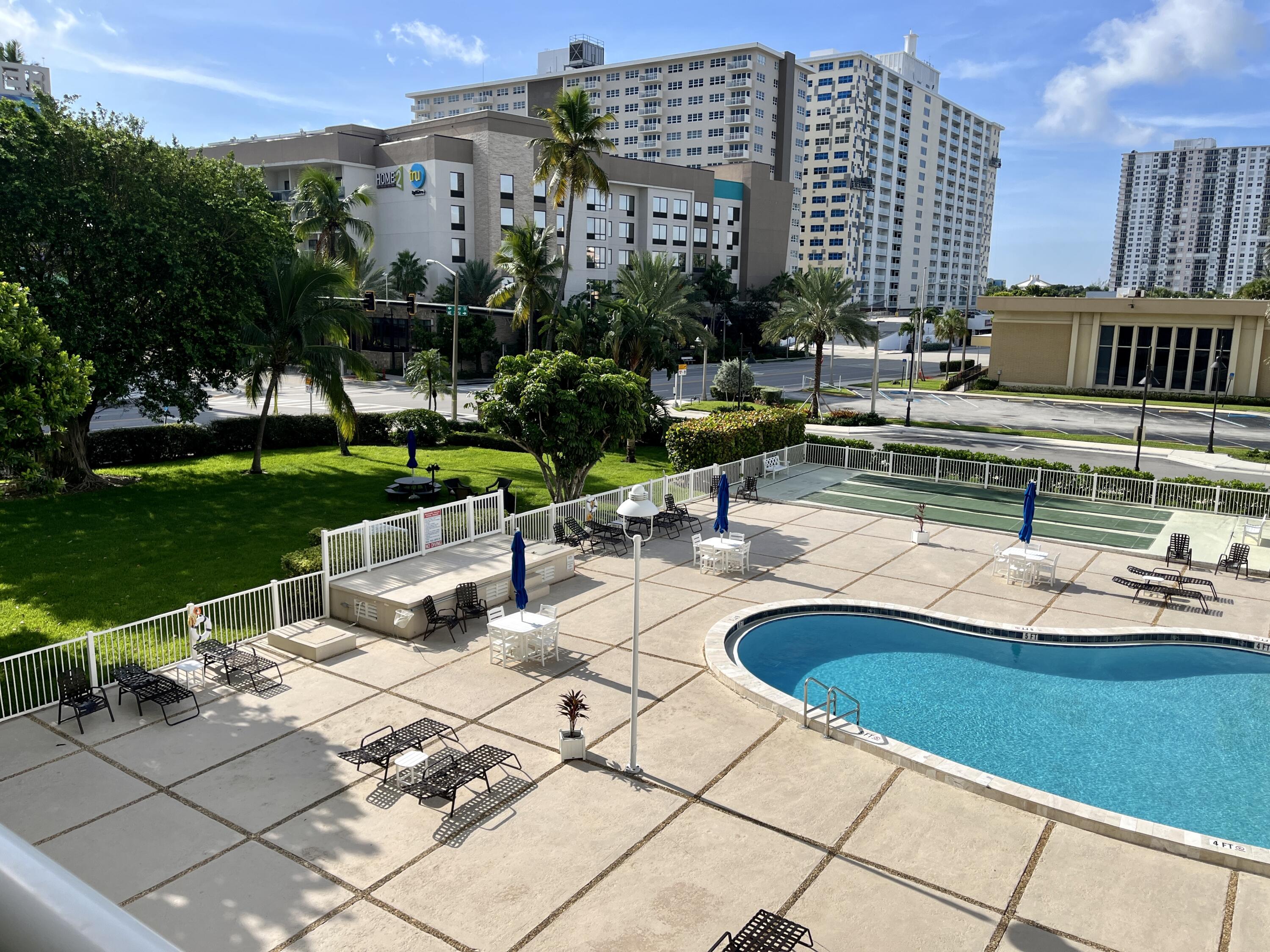 201 North Ocean Boulevard, Unit 302 Pompano Beach, FL 33062 - Photo 22 of 39 a swimming pool with outdoor seating and plants