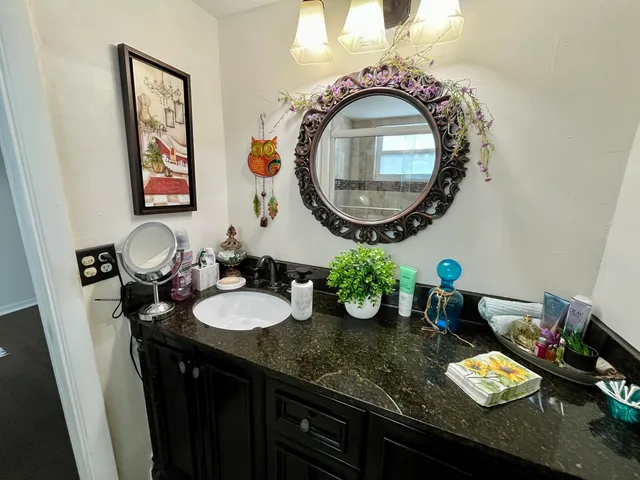 a bathroom with a granite countertop double vanity and a mirror