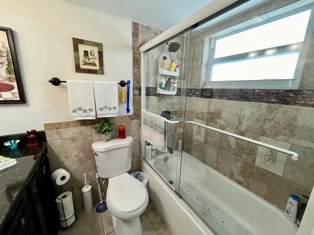 a bathroom with a granite countertop toilet sink and mirror