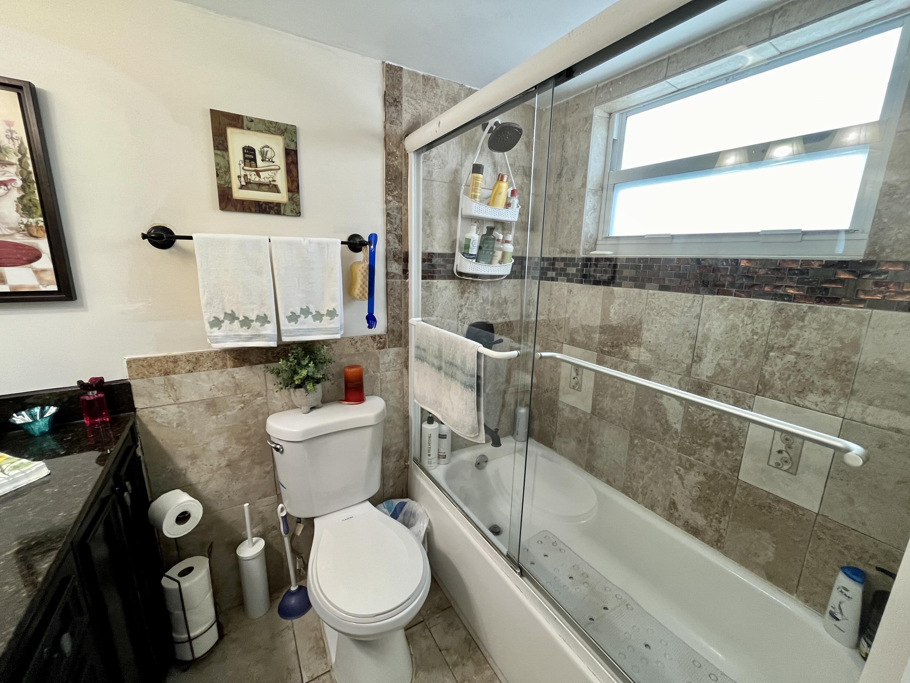 201 North Ocean Boulevard, Unit 302 Pompano Beach, FL 33062 - Photo 27 of 39 a bathroom with a granite countertop toilet sink and mirror