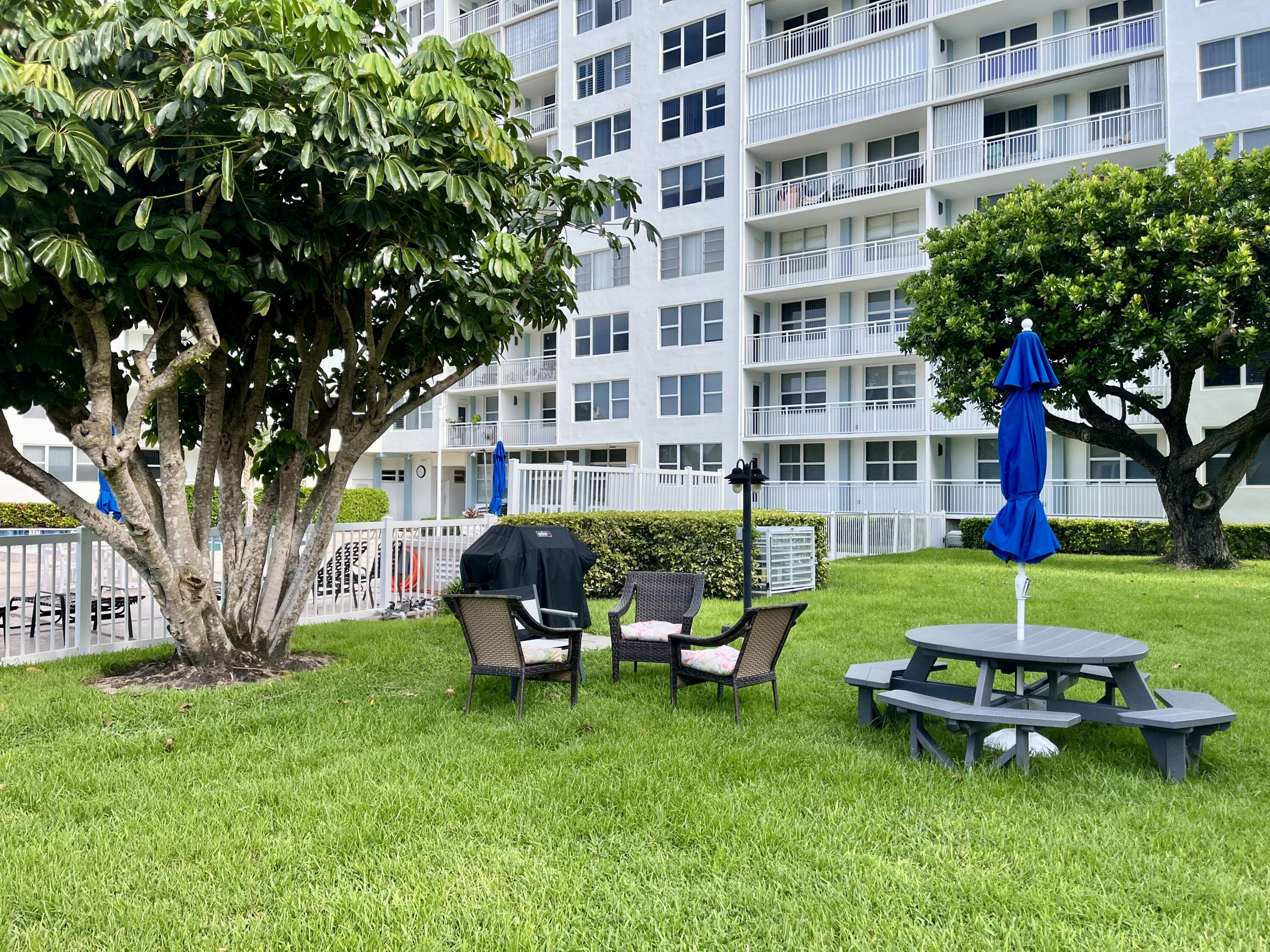 201 North Ocean Boulevard, Unit 302 Pompano Beach, FL 33062 - Photo 33 of 39 a view of a building with a yard and sitting area