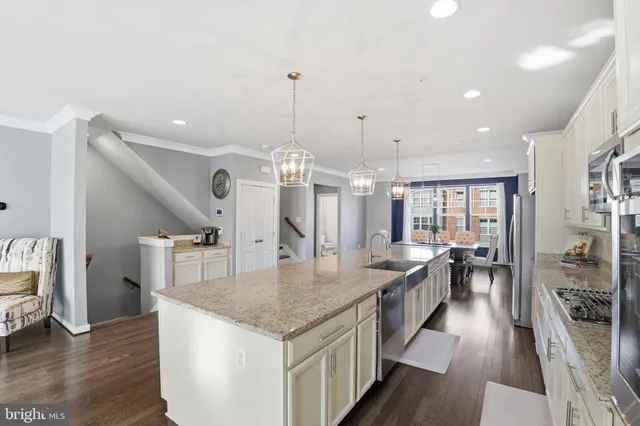 a kitchen with stainless steel appliances granite countertop a stove and wooden floor