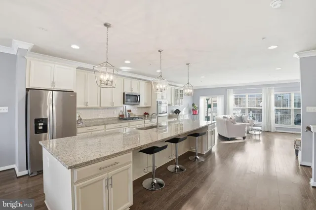 a large kitchen with kitchen island a large counter top stainless steel appliances and a center island