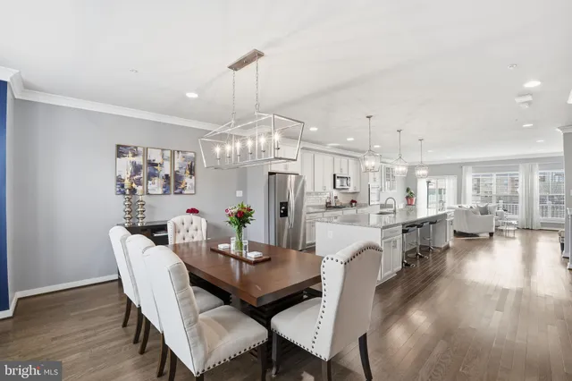 a view of a dining room with furniture a chandelier and wooden floor