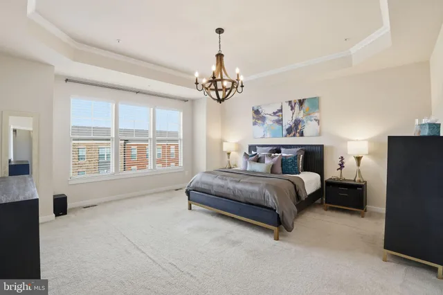 a spacious bedroom with a bed couch and window