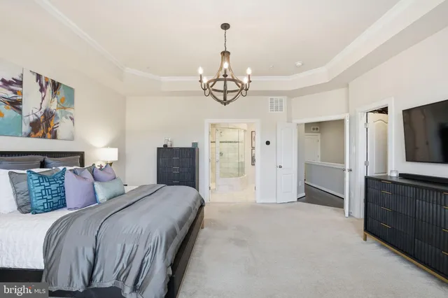 a spacious bedroom with a bed and a chandelier