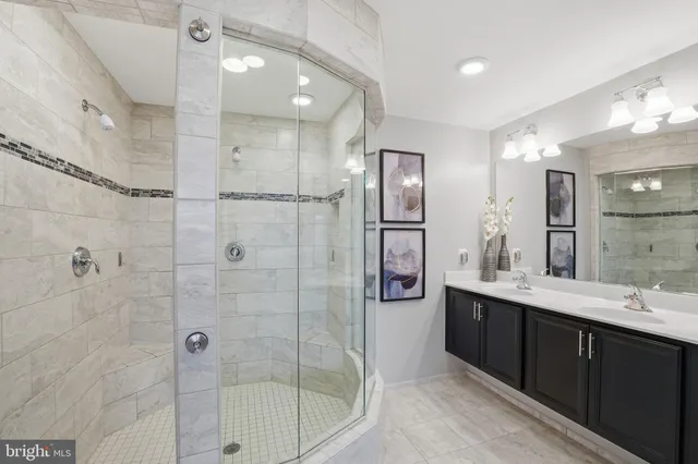 a bathroom with a double vanity sink mirror and shower