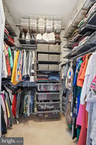 a view of walk in closet with clothes