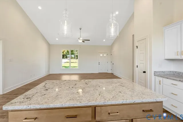 a large kitchen with stainless steel appliances granite countertop a stove top oven a sink dishwasher and a refrigerator