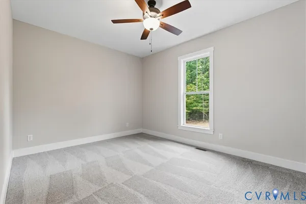 an empty room with a window and a fan