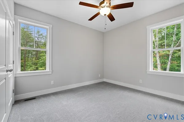 an empty room with a window and a fan