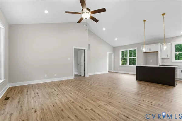 a view of an empty room with window and wooden floor