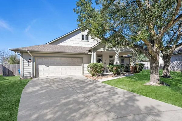 a front view of a house with yard and green space