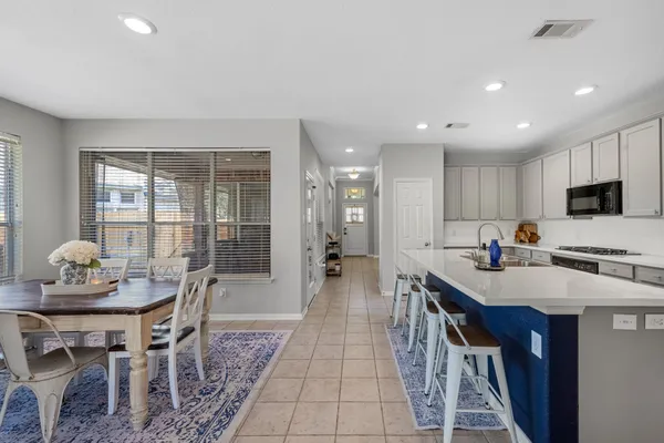 a kitchen with stainless steel appliances a dining table chairs and granite counter tops