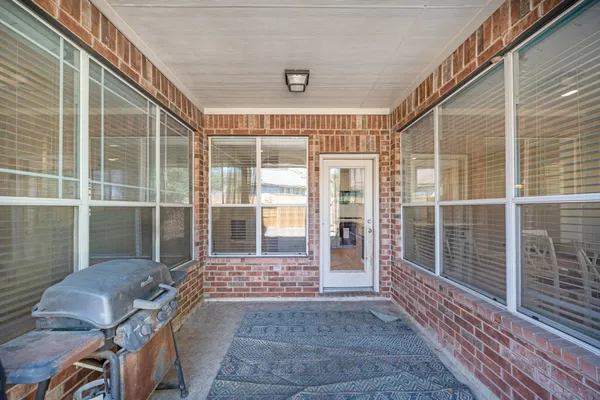 a view of a porch with a table and chairs