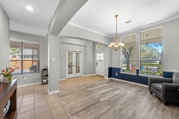 a spacious bedroom with a large bed and a chandelier