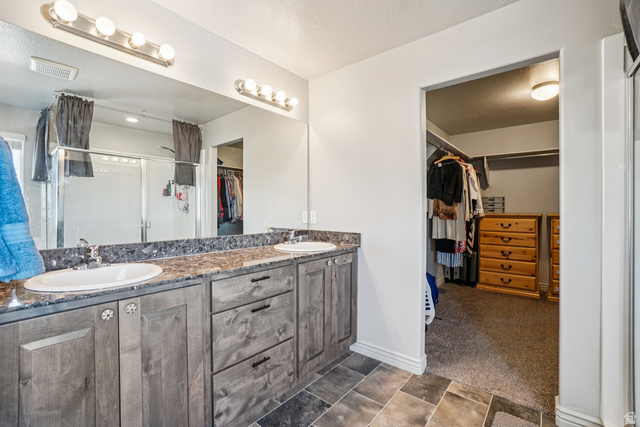 203 North 1900th Street West Mapleton, UT 84664 - Photo 17 of 48 Bathroom featuring a double vanity with stone-finish countertop, undermount sinks, and wood-finish cabinetry