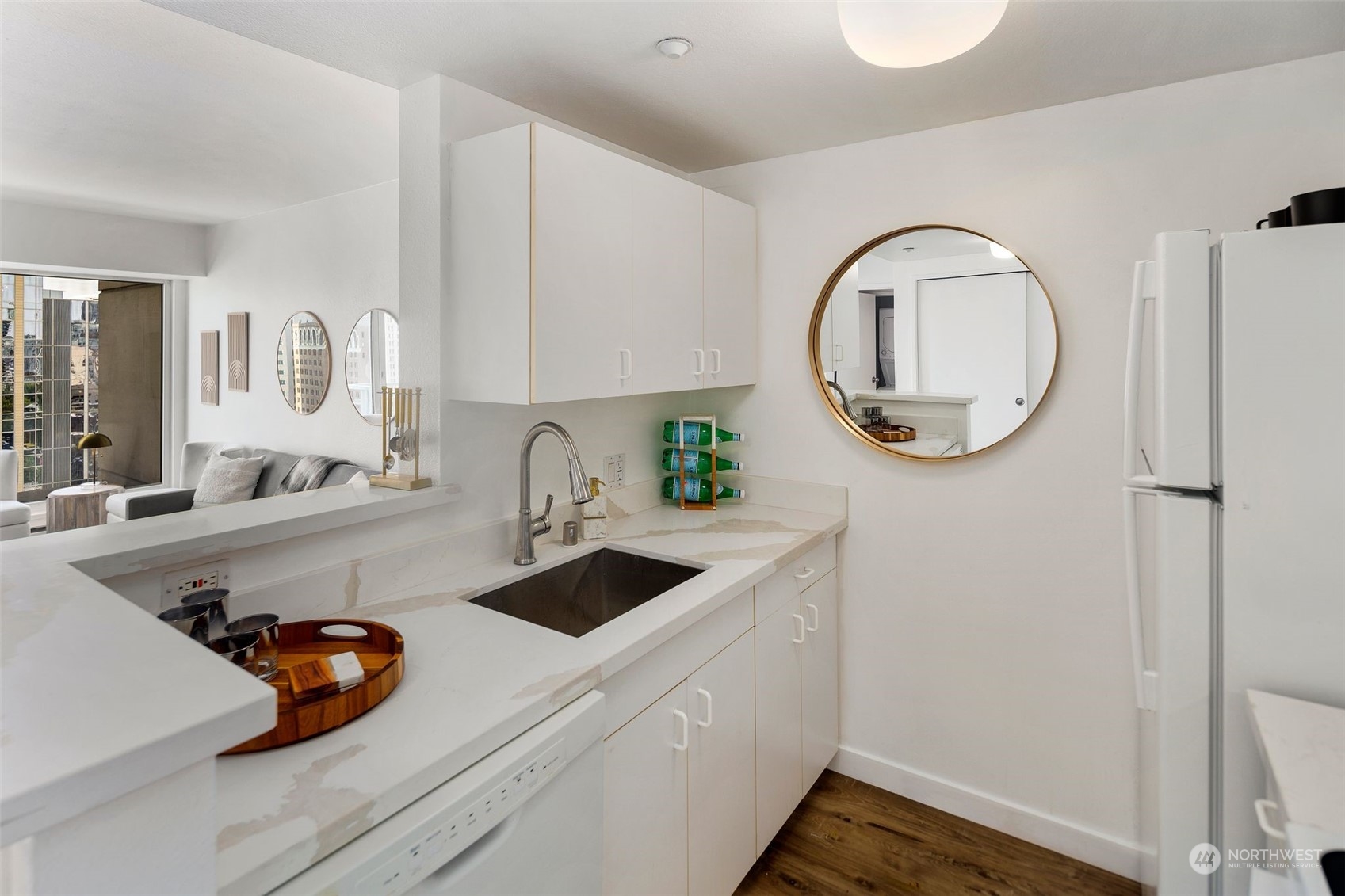 1415 2nd Avenue, Unit 2008 Seattle, WA 98101 - Photo 13 of 36 a kitchen with a sink a stove and a wooden floor