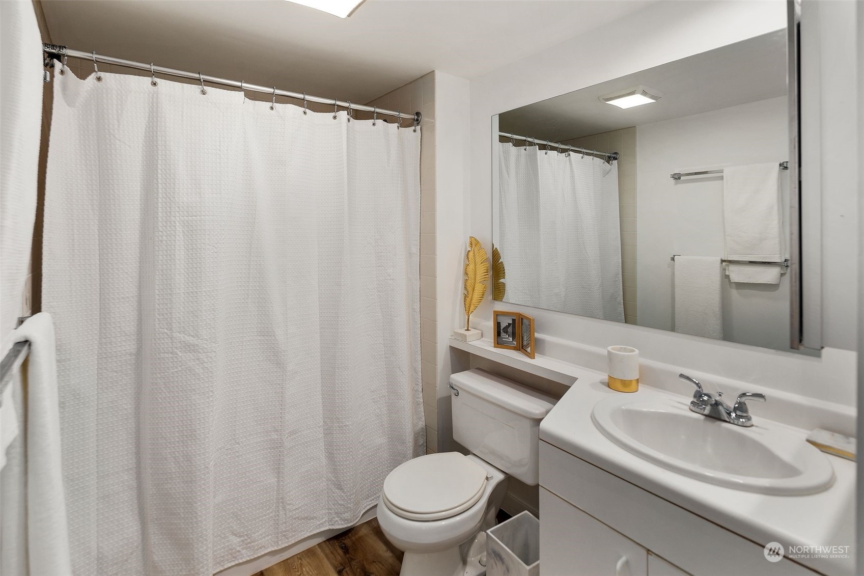 1415 2nd Avenue, Unit 2008 Seattle, WA 98101 - Photo 17 of 36 a bathroom with a sink a toilet and shower curtain