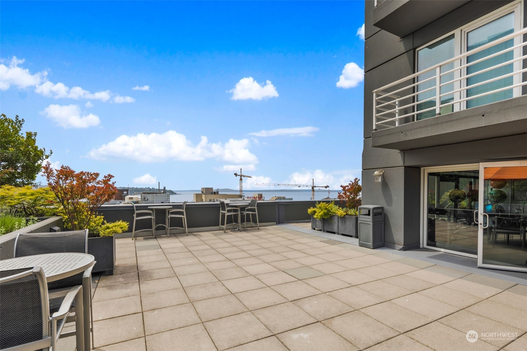 1415 2nd Avenue, Unit 2008 Seattle, WA 98101 - Photo 26 of 36 a view of a patio with dining table and chairs with a barbeque grill and plants