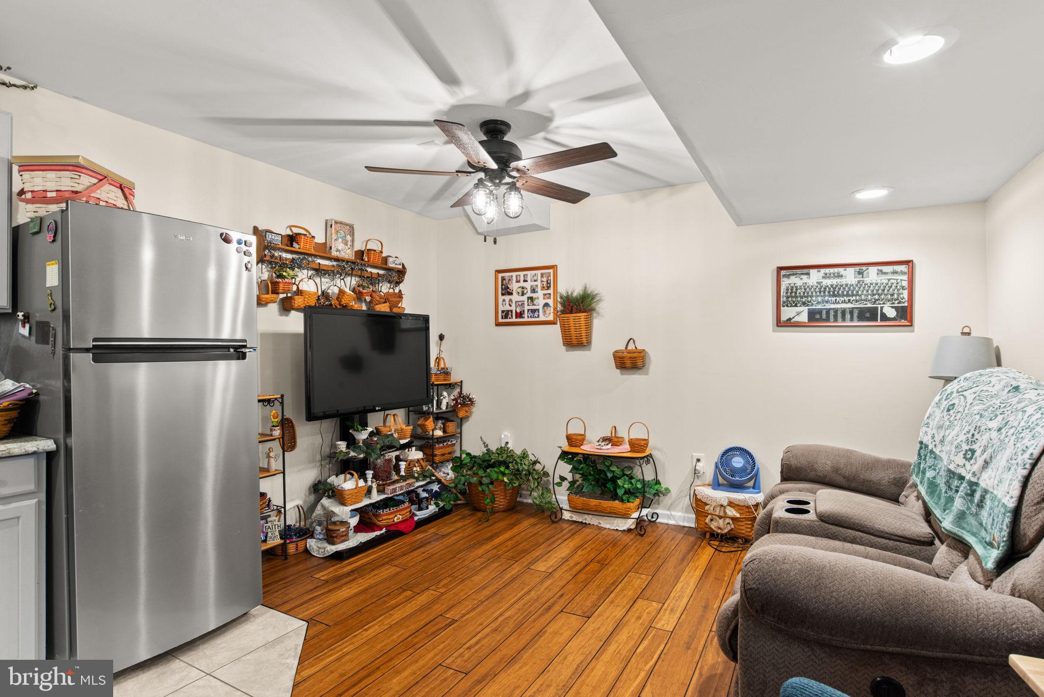 19773 Haugh Road Stewartstown, PA 17363 - Photo 45 of 58 a living room with furniture a flat screen tv and a refrigerator