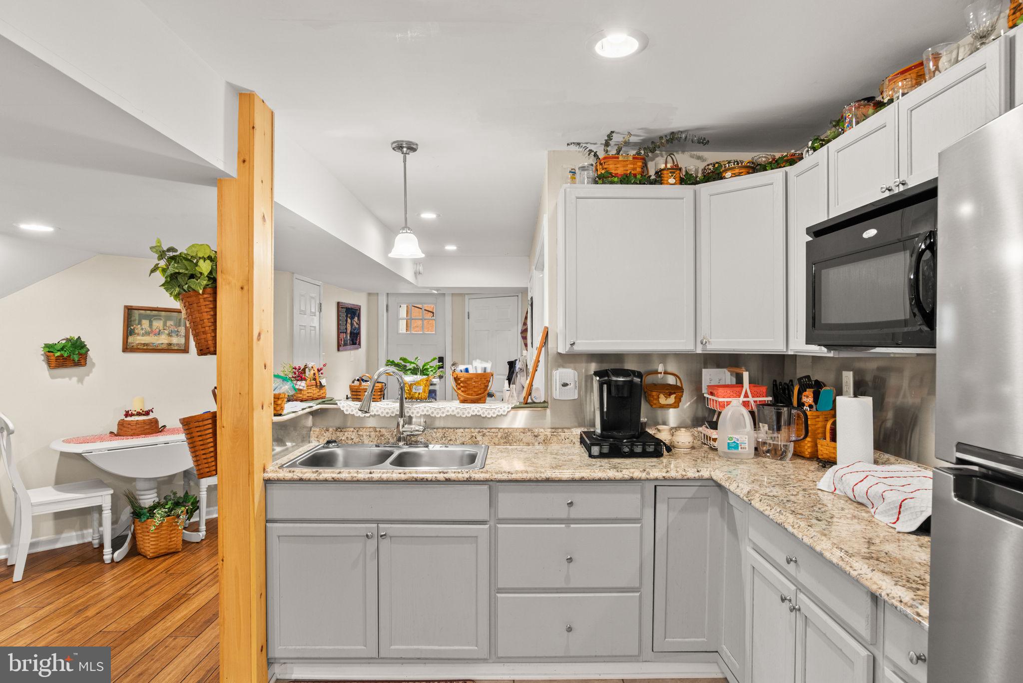 19773 Haugh Road Stewartstown, PA 17363 - Photo 48 of 58 a kitchen with stainless steel appliances granite countertop a sink dishwasher and cabinets with wooden floor