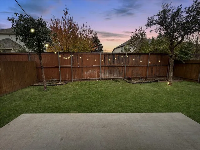a view of backyard with wooden fence