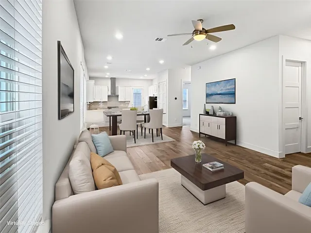 a living room with furniture kitchen view and a window