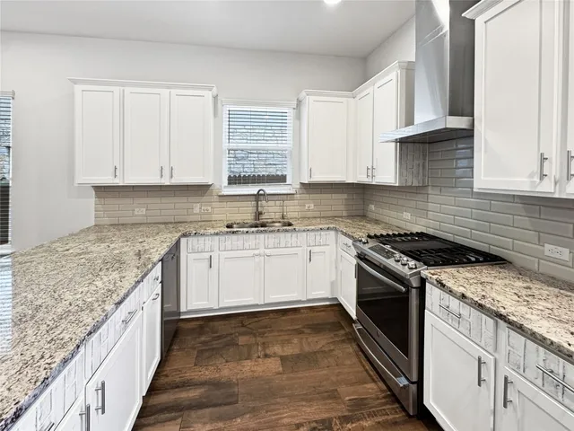a kitchen with granite countertop cabinets stainless steel appliances and a window