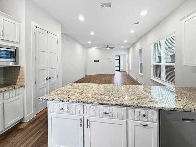 a kitchen with kitchen island granite countertop a stove and a sink