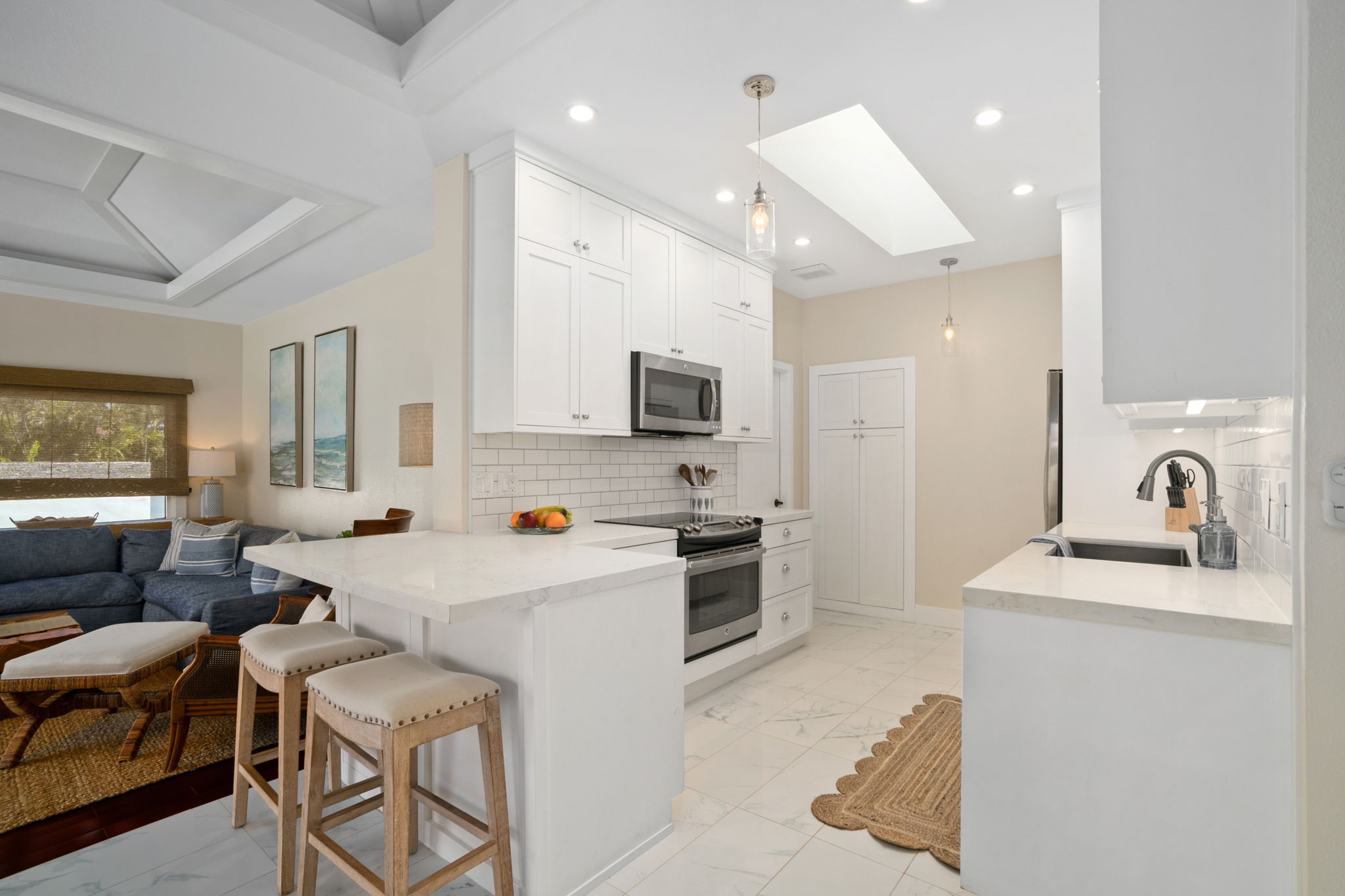 1753 Kelaukia Street Koloa, HI 96756 - Photo 10 of 27 a kitchen with stainless steel appliances a stove a sink a refrigerator white cabinets and couches with wooden floor