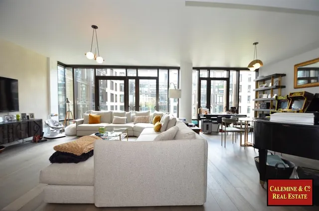 a living room with furniture kitchen view and a flat screen tv