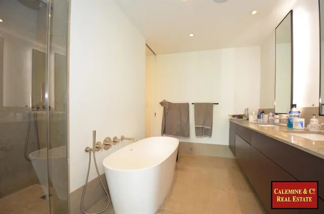 a bathroom with a white tub shower and sink