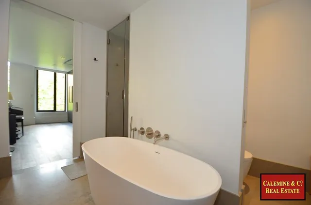 a living room with furniture a flat screen tv and a floor to ceiling window