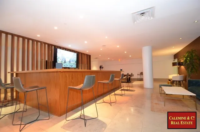 a living room with lots of furniture and kitchen view